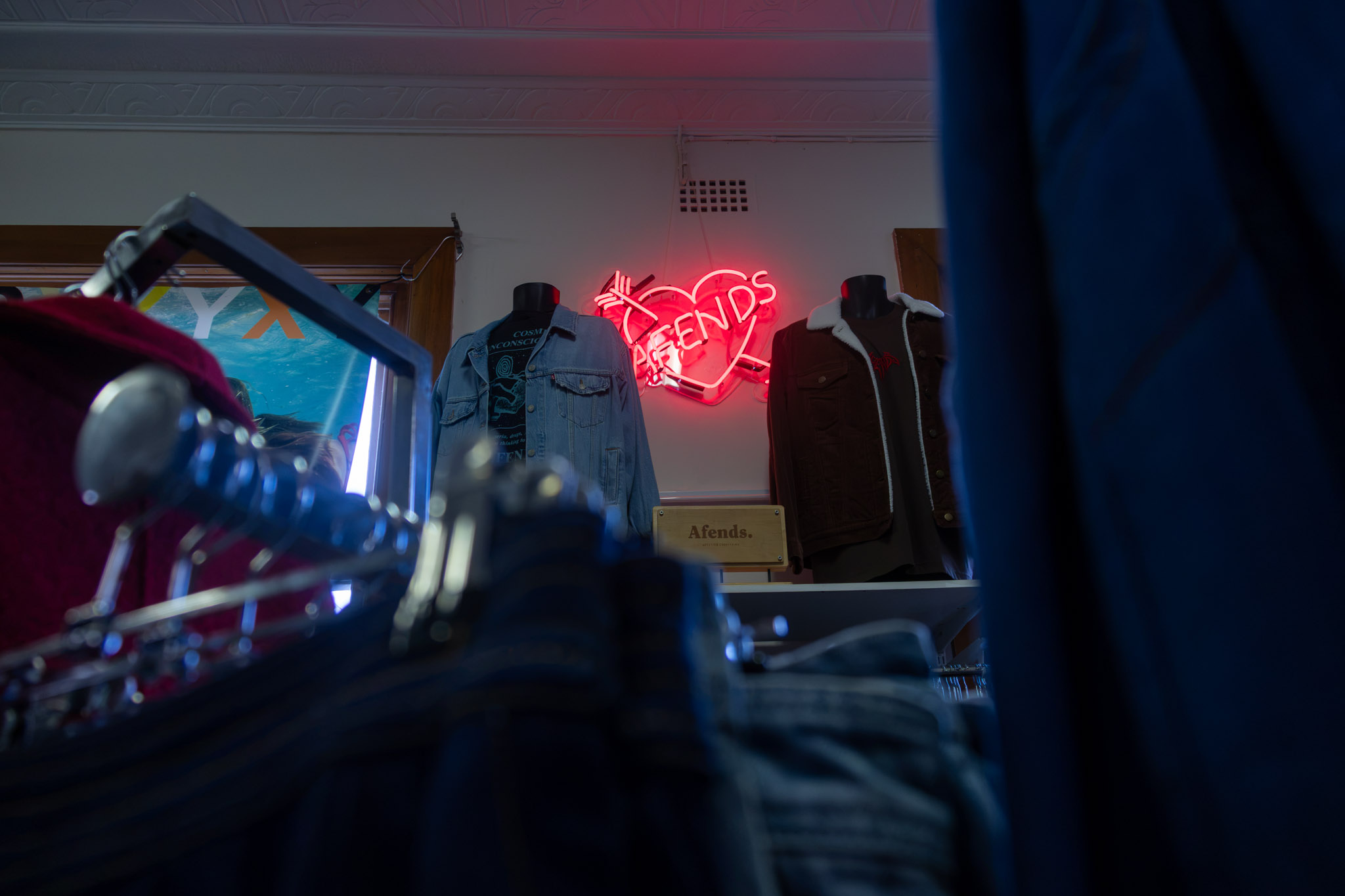 Neon sign and denim jackets inside the shop.