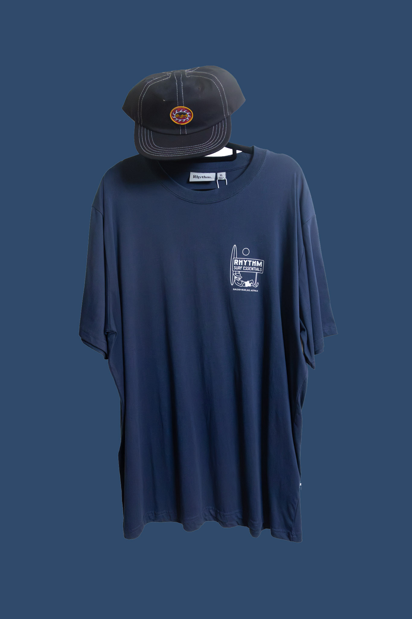 Navy graphic tee and cap, representative of the menswear range.